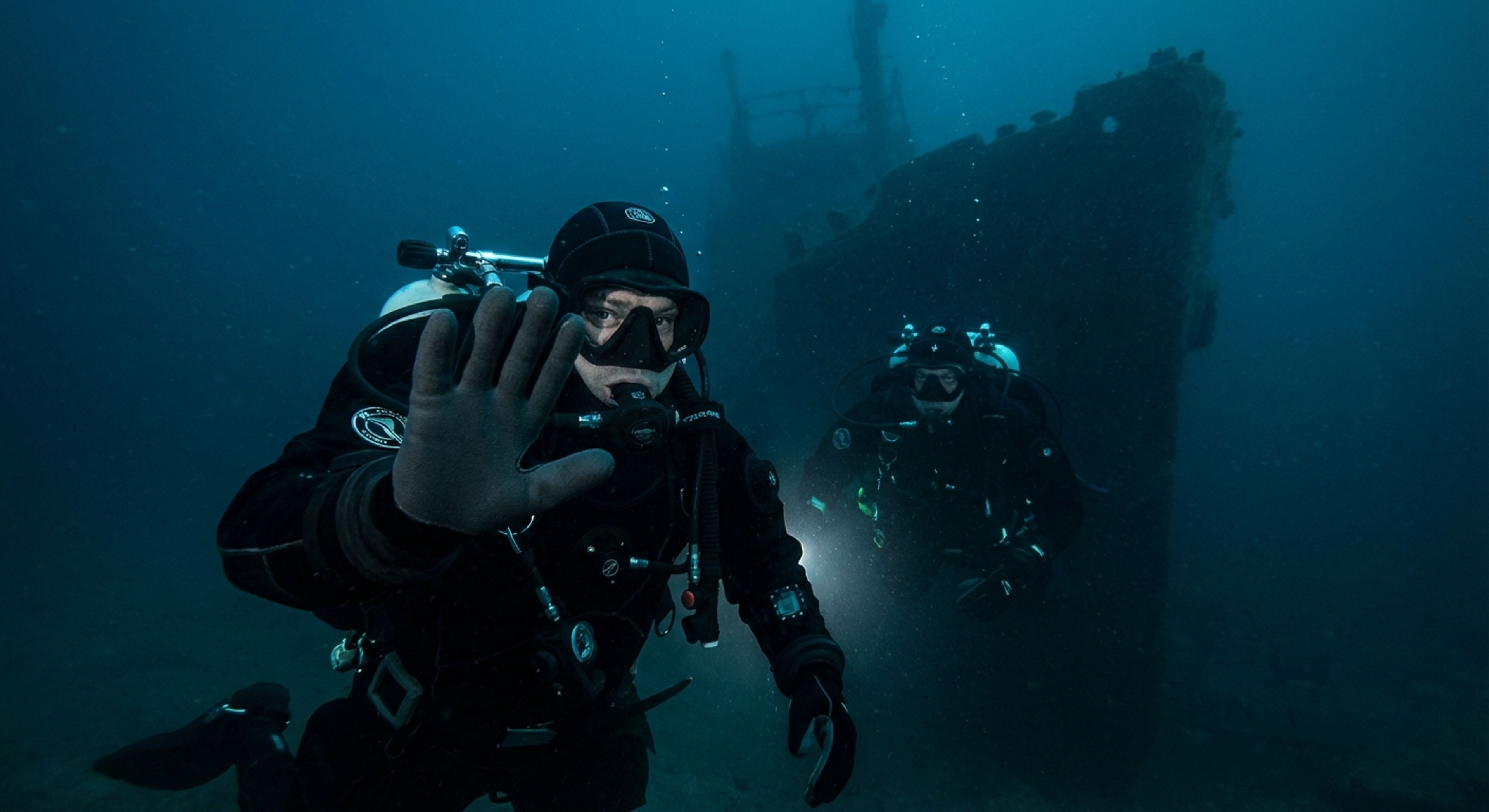 A diver underwater warning another diver